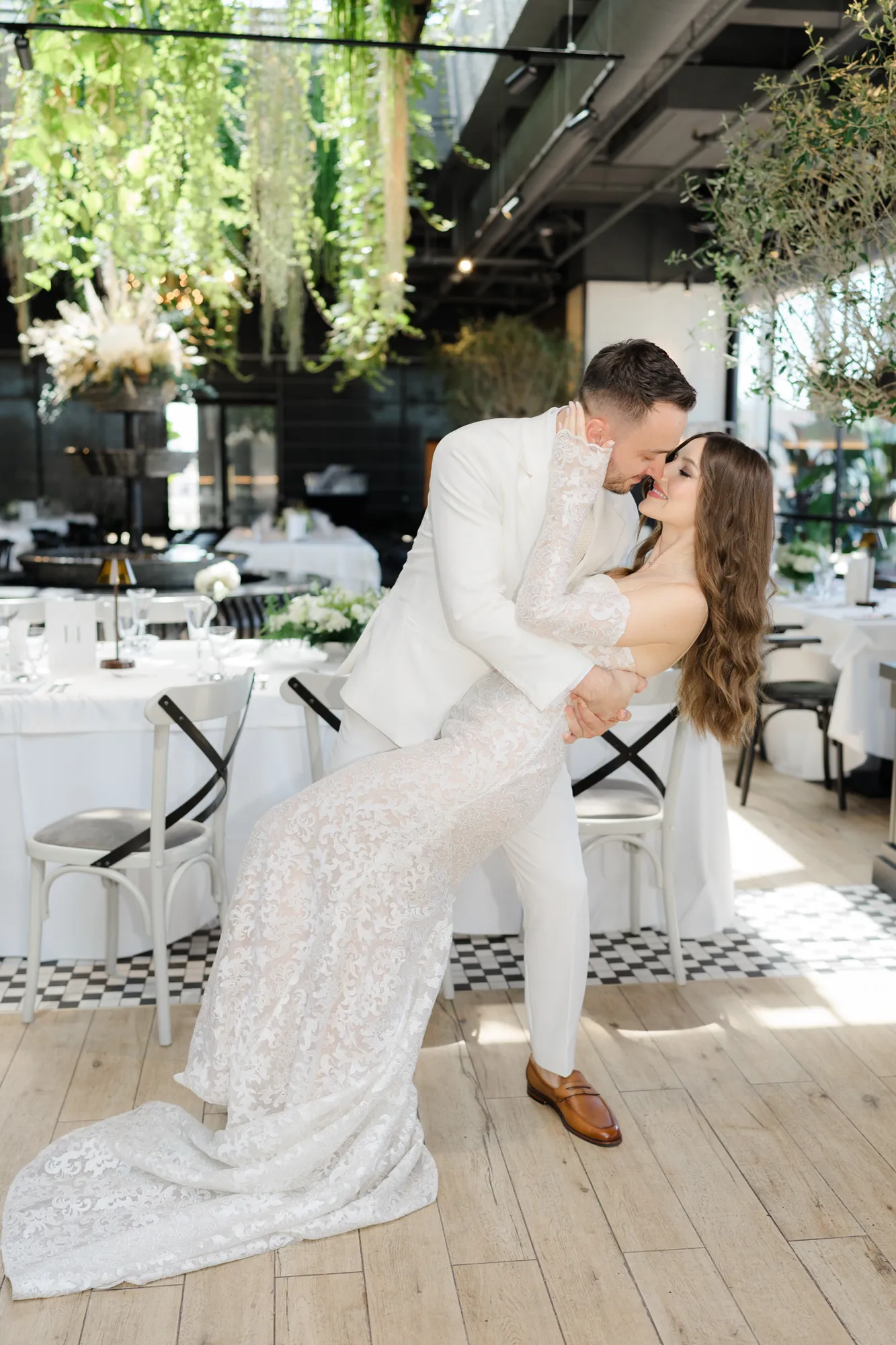Mirii îmbrățișați într-o plecare elegantă, rochie de mireasă cu trenă
