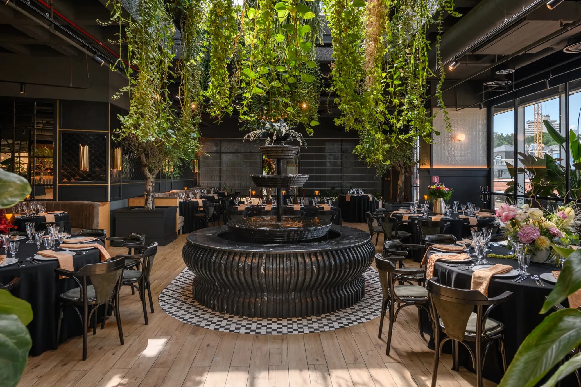 Sala luminoasă cu fântână, măslini decorativi și priveliște spre oraș